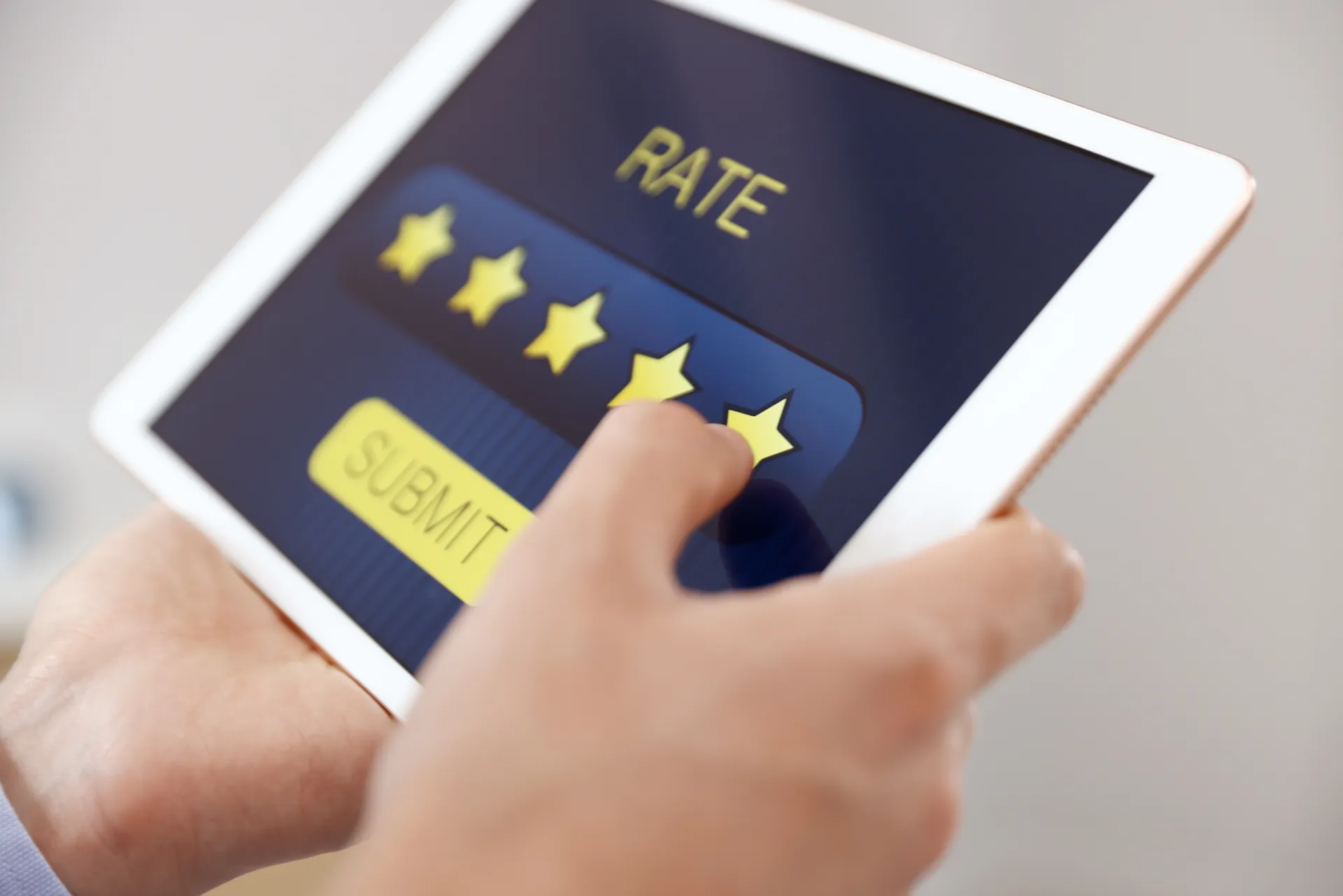 Hand tapping a five-star rating on a tablet