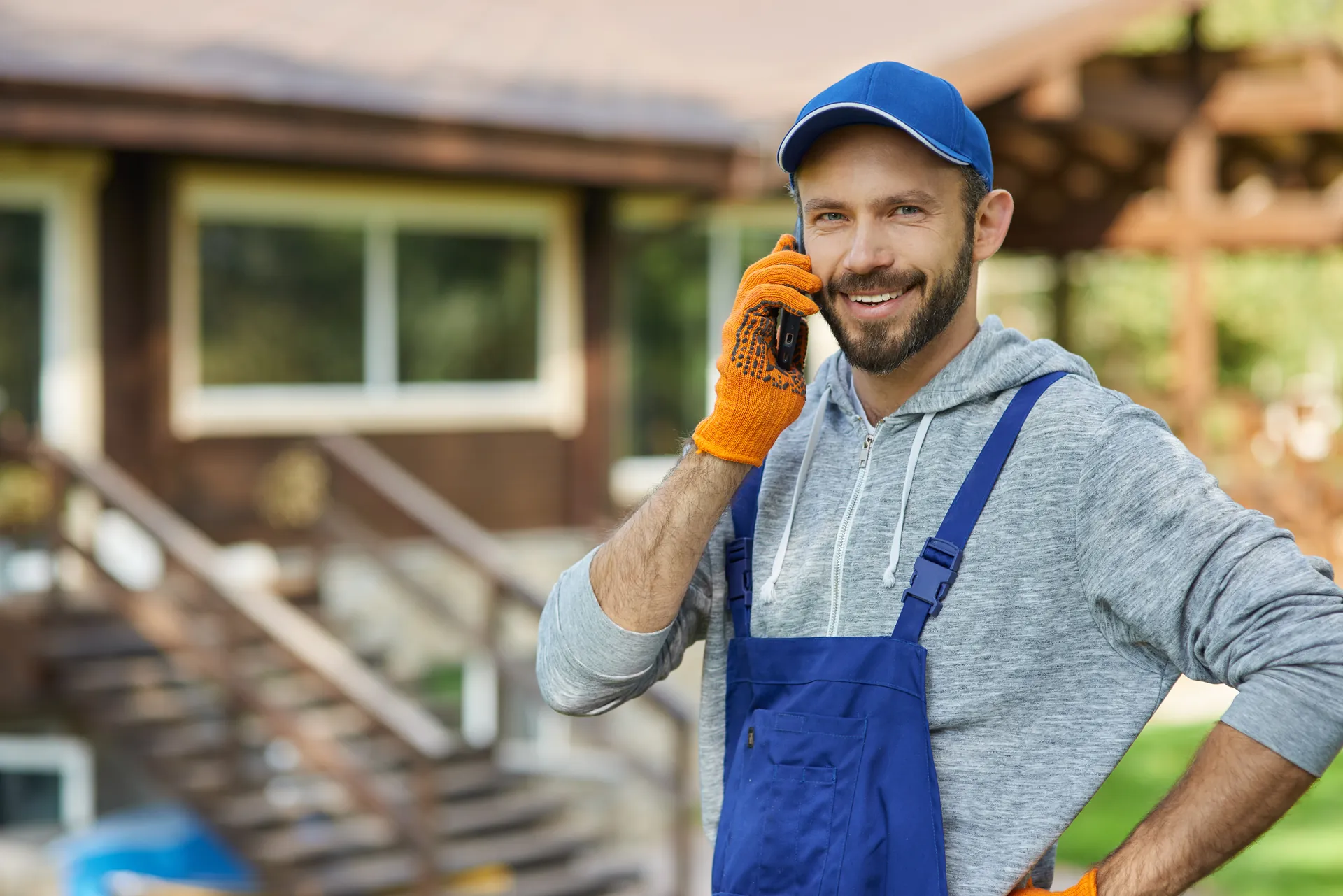 Plumber answering his phone outside a house